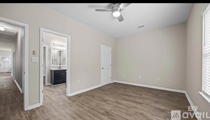 A spacious room with a ceiling fan and lighting fixtures.