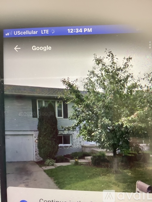 A tree in front of a house with a Google search bar on the screen.