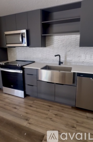 A modern kitchen with a stainless steel sink and oven.