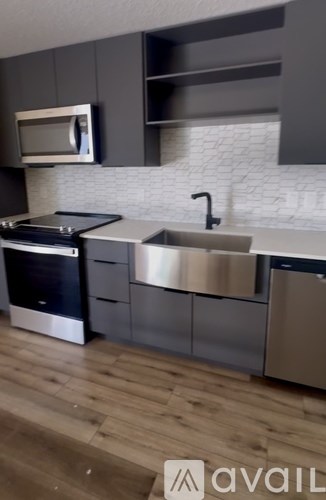 A modern kitchen with a stainless steel sink and oven.