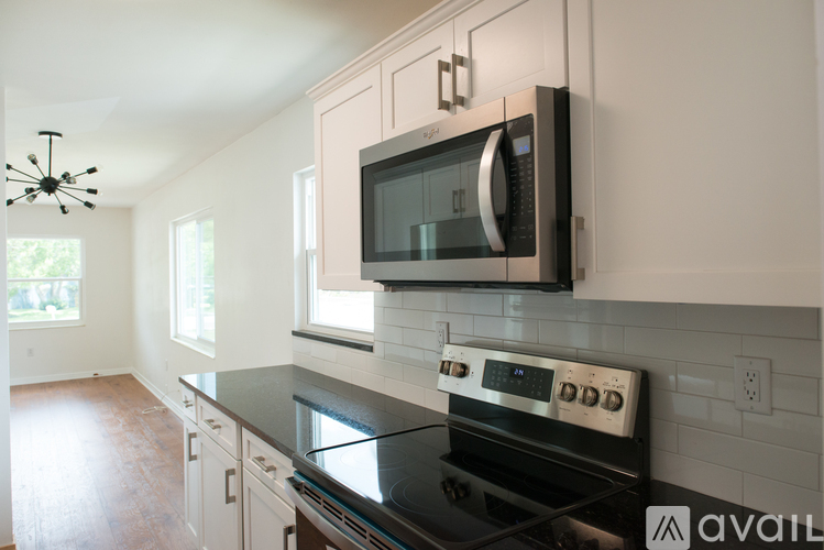 A kitchen with a black stove top oven and a black microwave above it.