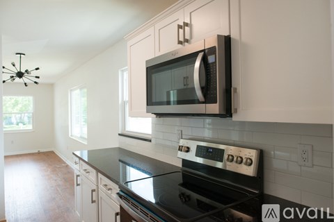 A kitchen with a black stove top oven and a black microwave above it.