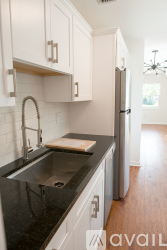 A kitchen with a sink and a refrigerator.