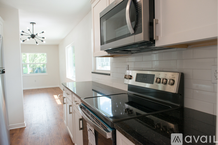 A kitchen with a black stove top oven and white cabinets.