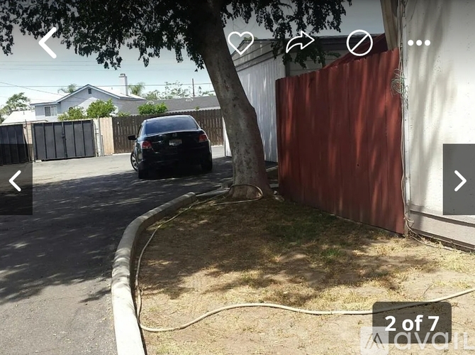 A black car is parked on the side of a street.