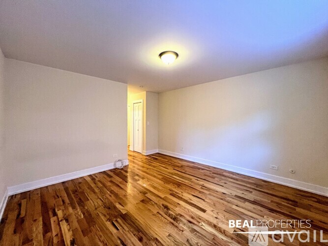A room with wooden flooring and a white ceiling with a light fixture.