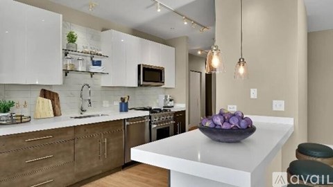 A modern kitchen with a white island and wooden cabinets.