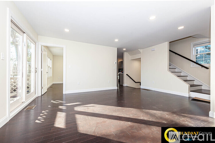 A spacious room with a staircase and a window.