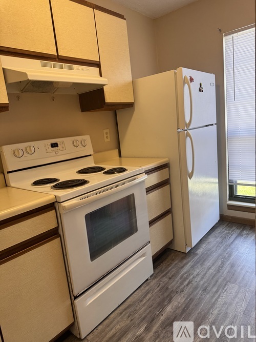 A kitchen with a white stove and refrigerator.