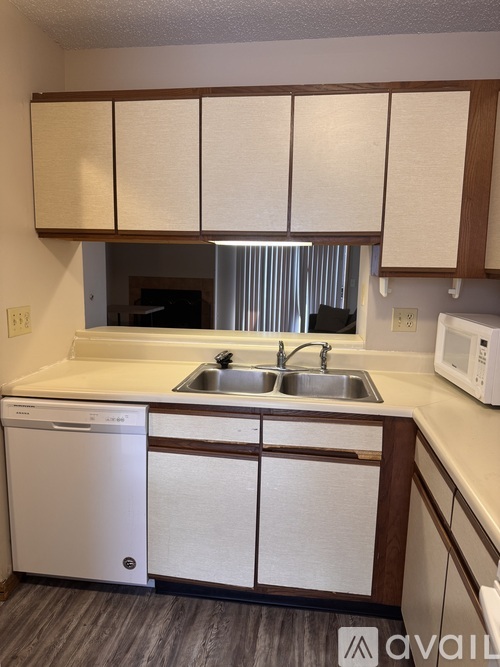 A kitchen with a white dishwasher and a white microwave.