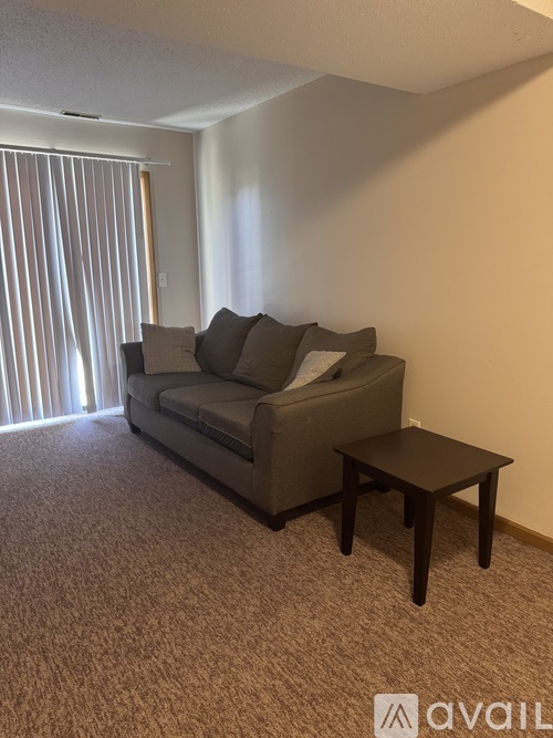 A living room with a grey couch and a small table.