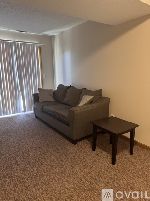 A living room with a grey couch and a small table.