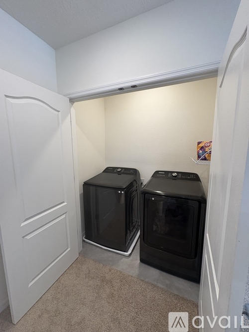 Two black ovens are in a white kitchen.