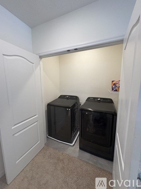 Two black ovens are in a white kitchen.