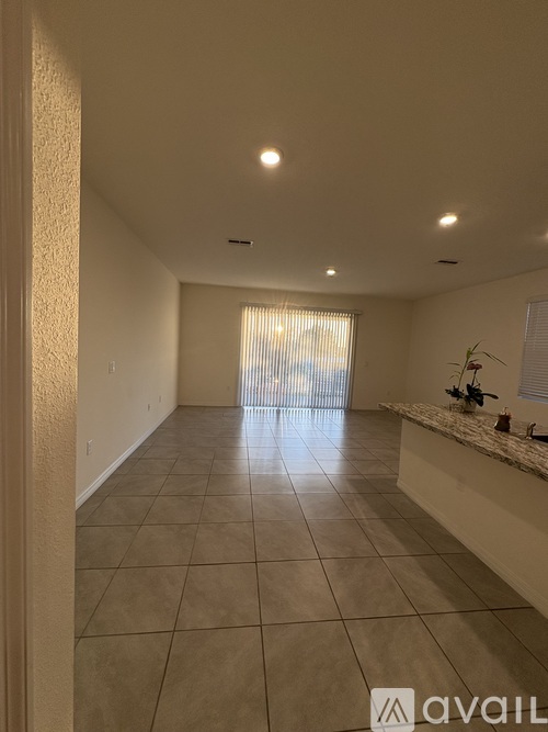 A spacious room with tiled flooring and a counter on the right side.