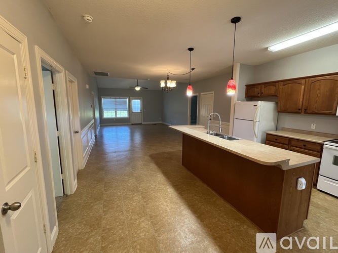 A kitchen with a white refrigerator and brown countertops.