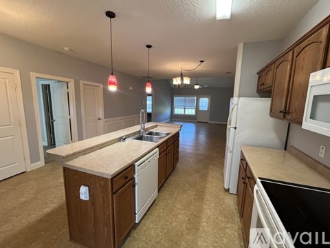 A kitchen with a sink, stove, and cabinets.