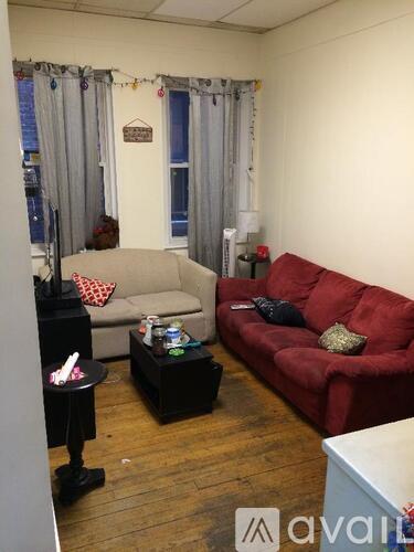 A living room with a red couch and a grey couch with a coffee table between them.
