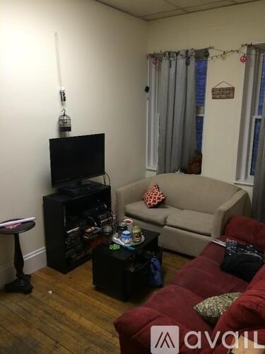 A living room with a red couch and a black entertainment center.