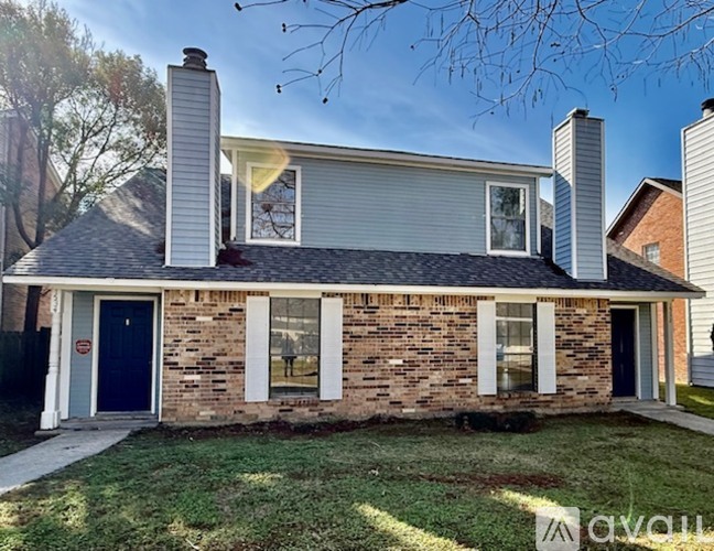 A house with a blue door and a brick wall.