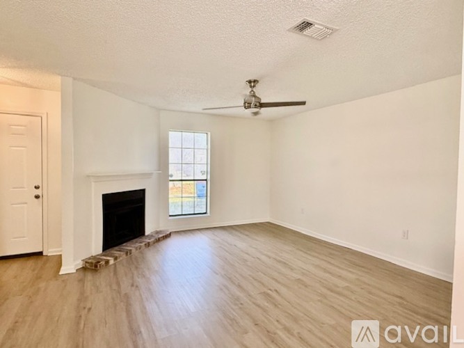 A room with a fireplace and a ceiling fan.