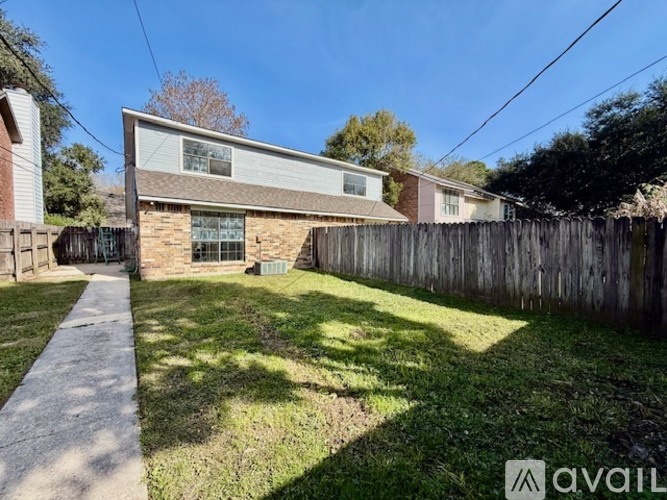 A house with a fence and a walkway in front.