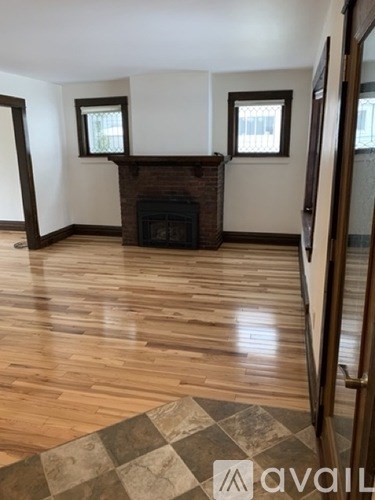 A room with a fireplace and wood flooring.