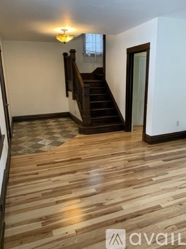 A room with wooden flooring and a staircase.