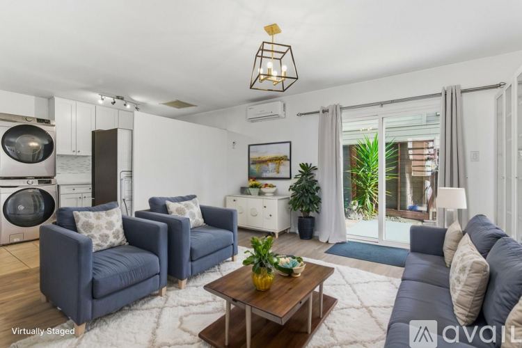 A living room with a blue couch, a coffee table, and a large window.