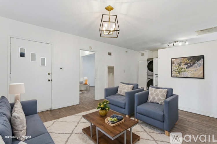 A living room with a grey couch, a coffee table, and a painting on the wall.