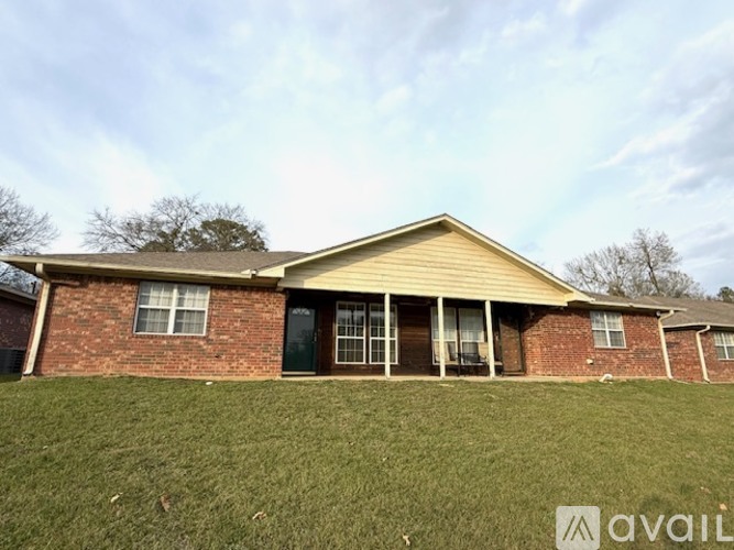 A house with a brick facade and a yellow roof is available for purchase.