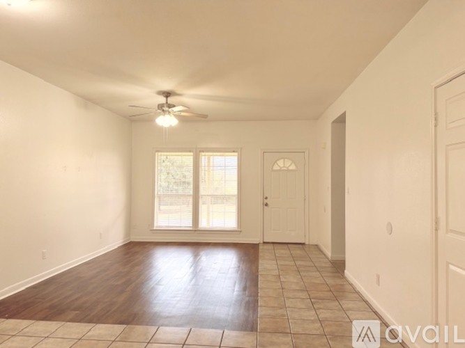 Empty room with a ceiling fan and tiled floor.