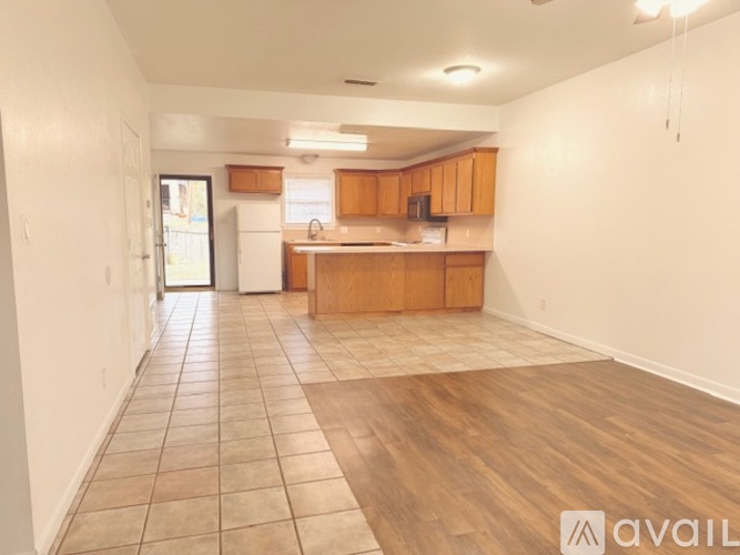 A kitchen with wooden cabinets and a tiled floor.