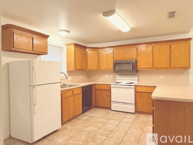 A kitchen with wooden cabinets and a white refrigerator.