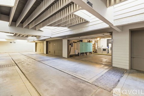 A spacious garage with a concrete floor and a ceiling with exposed beams.