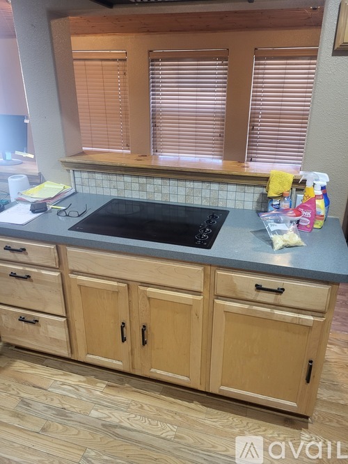 A kitchen with wooden cabinets and a black countertop.