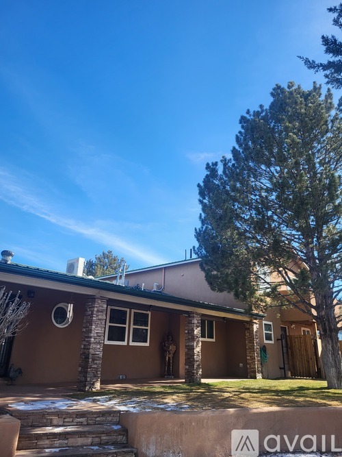 A house with a brown exterior and a tree in front of it.