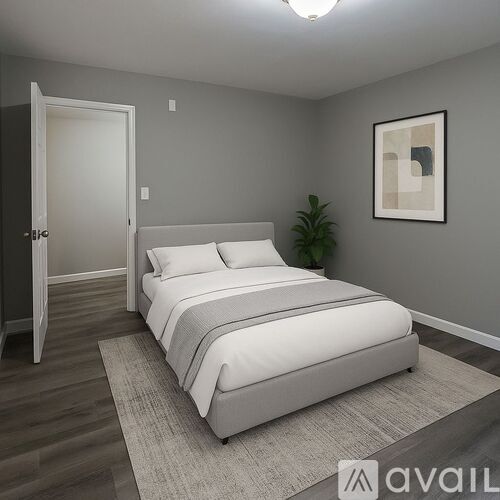 A bedroom with a large bed and a plant.