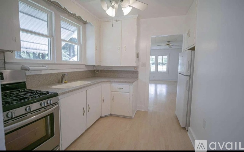 A kitchen with white cabinets and a black stove top.