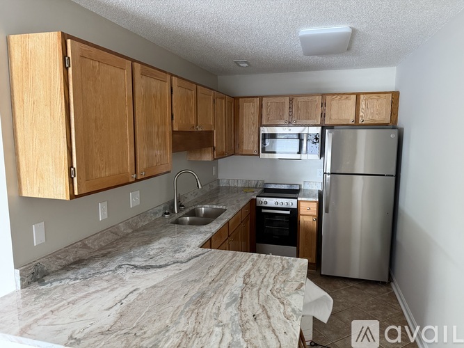 A kitchen area with a refrigerator, stove, and oven.