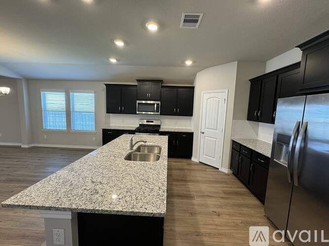 A kitchen with a granite countertop and stainless steel appliances.