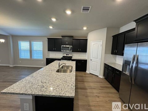 A kitchen with a granite countertop and stainless steel appliances.