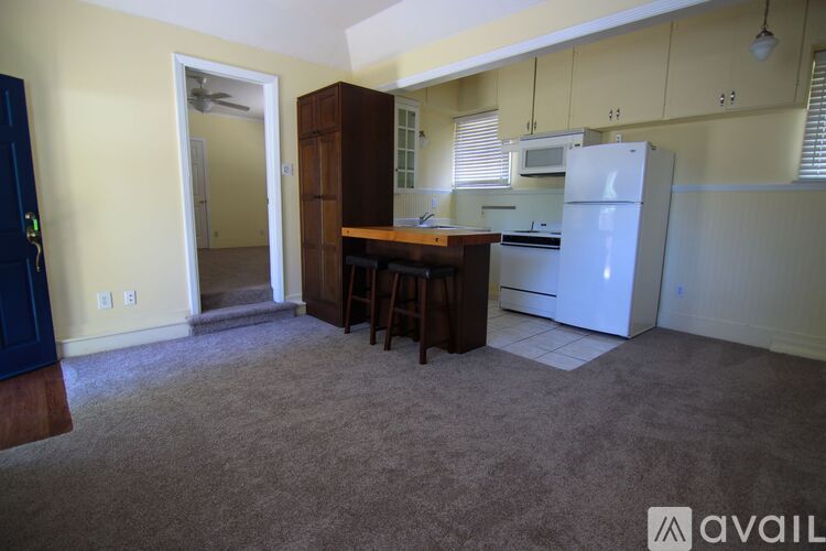 A kitchen with a white refrigerator, microwave, and wooden cabinets.