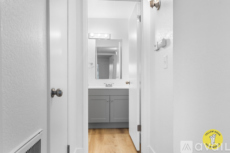 A black refrigerator is in a kitchen with a white stove and oven.