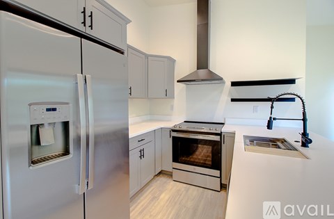 A modern kitchen with a stainless steel refrigerator and oven.