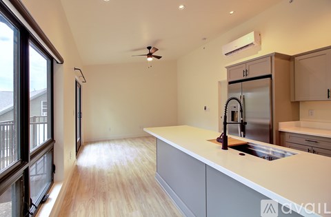 A kitchen with a white counter and a stainless steel refrigerator.