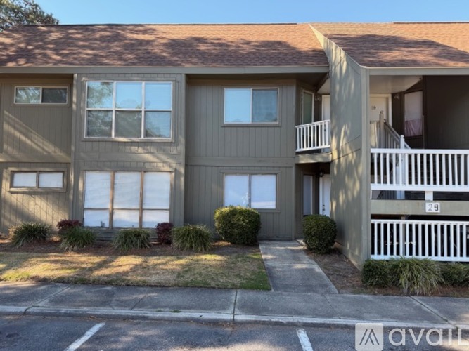 A two-story apartment building with a balcony on the second floor.