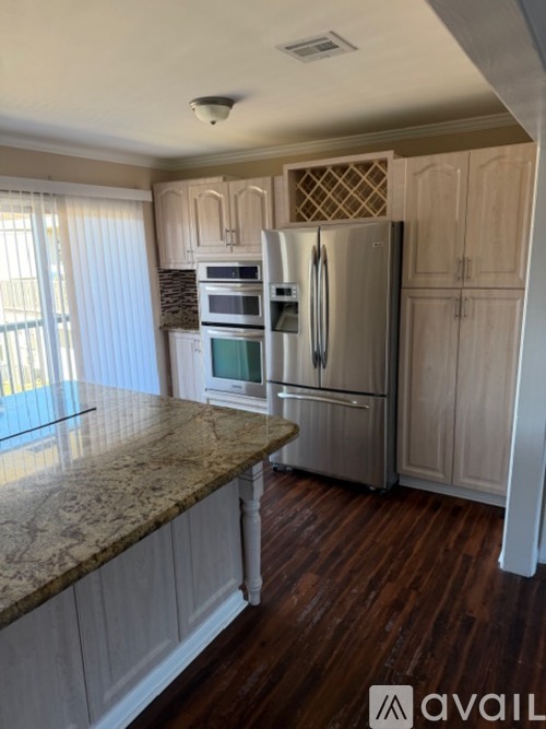 A kitchen with a granite countertop and stainless steel appliances.