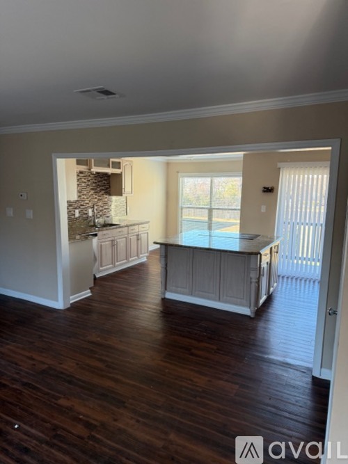 A room with wooden floors and a window overlooking a pool.