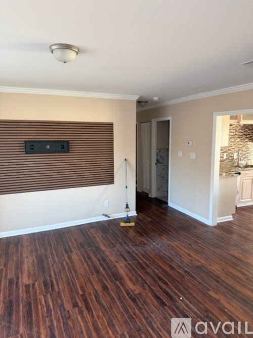 A room with wooden floors and a window with blinds.